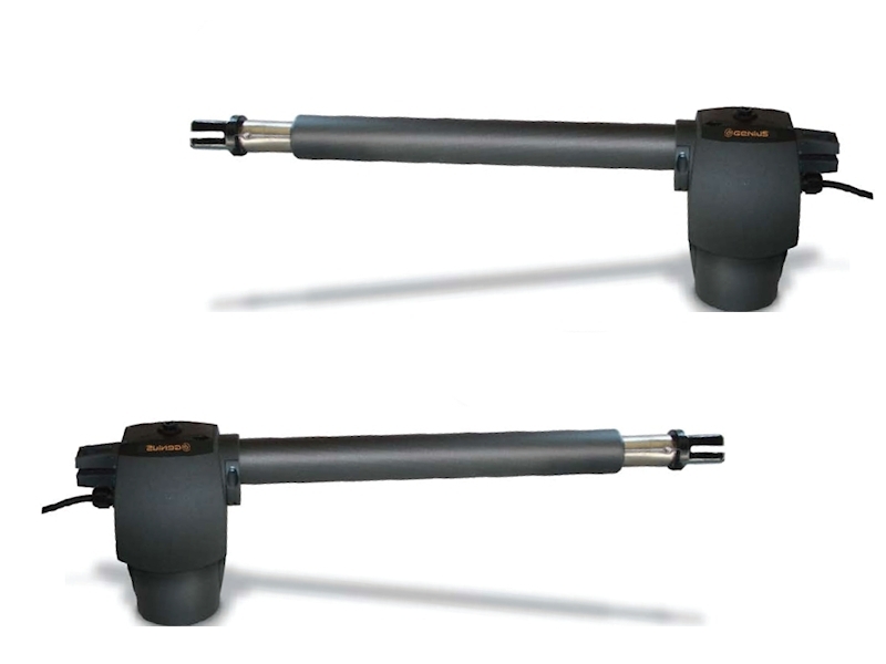 Dwa siłowniki elektryczne Genius z metalowymi ramionami, złączone przewodem, elementy napędowe ukryte w ciemnoszarych obudowach z logo Genius, wyposażone w końcówki przegubowe do montażu.