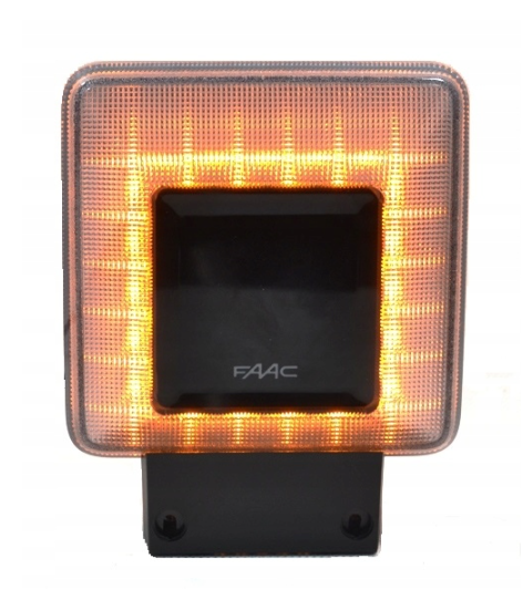 Czarna kwadratowa lampa ostrzegawcza marki FAAC z przezroczystą obudową z siatką, pojemnikiem na LED-y świecącymi światłem pomarańczowym, zamontowana na czarnej podstawie do przymocowania.