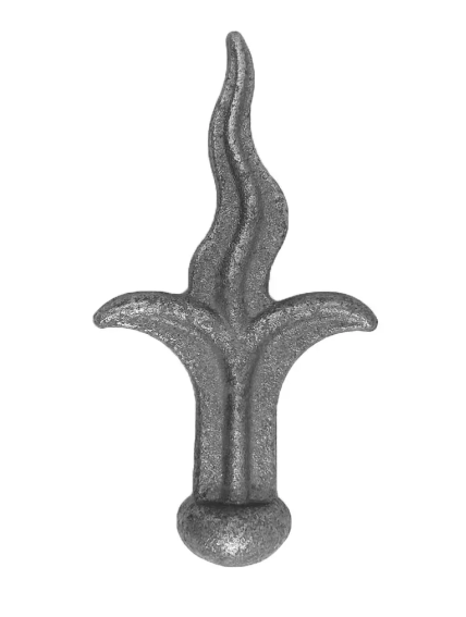 Na zdjęciu znajduje się metalowy element dekoracyjny o kształcie stylizowanego płomienia z dwiema symetrycznymi bocznymi wypustkami oraz trzecią, wyższą i falistą środkową częścią. Element jest wykonany z surowego, szarego metalu o chropowatej powierzchni i ma u podstawy zaokrąglony, kulisty zakończenie.