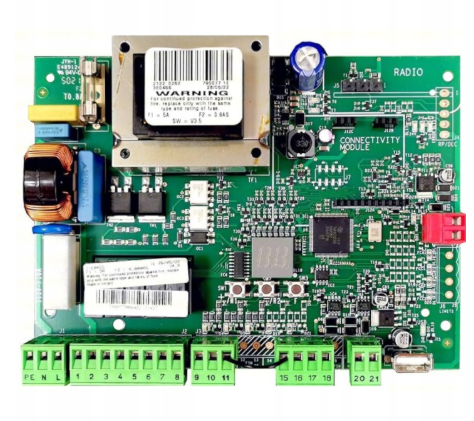 Zielona płytka elektroniczna FAAC z wieloma komponentami, złączami oraz dużym kondensatorem i przekaźnikiem, odpowiedzialna za sterowanie automatycznym napędem bramy.