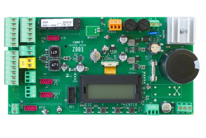 Zielona płytka elektroniczna CAME ZBB3 o prostokątnym kształcie, wyposażona w różne elementy elektroniczne, w tym wyświetlacz LCD, kondensatory, potencjometry i złącza śrubowe.